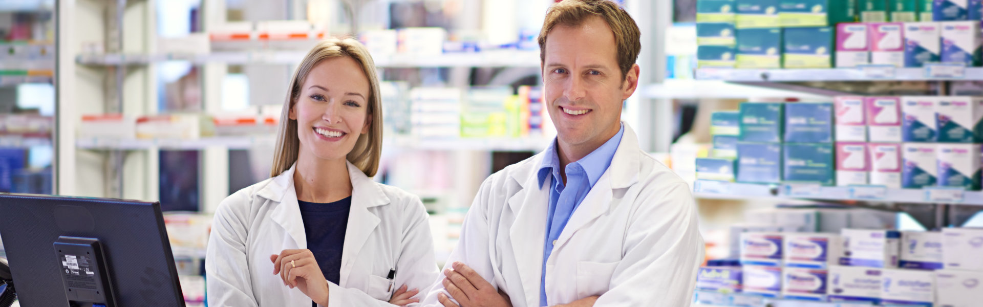 Portrait of two pharmacists standing at the prescription counter